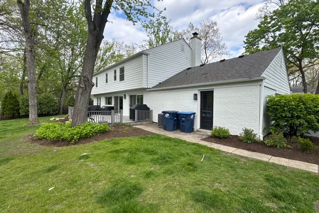 Rear elevation of the house from the lawn with the service walkway and condenser unit