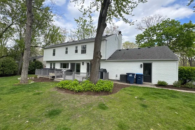 Rear of the house from the far lawn with the mature tree and planting beds