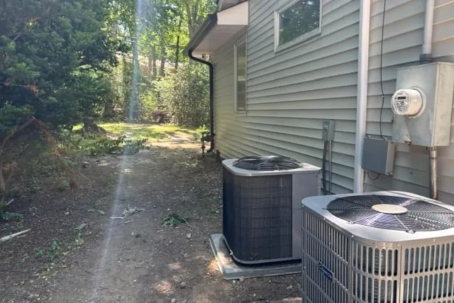 Site photograph of the side service strip with two AC condensers and the utility meter