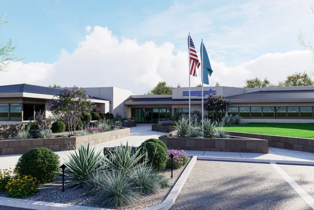 Rendering of the building entry with flagpoles and desert planting